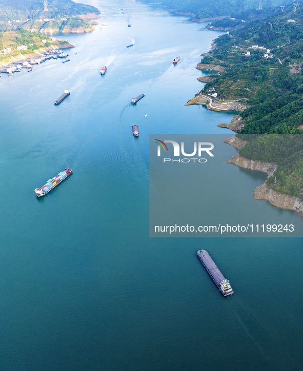 Transport ships are sailing in the waters in front of a dam in the Three Gorges reservoir area of the Yangtze River in Zigui County, Yichang...