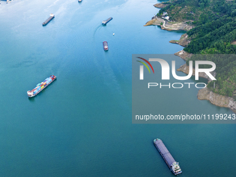 Transport ships are sailing in the waters in front of a dam in the Three Gorges reservoir area of the Yangtze River in Zigui County, Yichang...