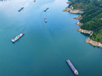 Transport ships are sailing in the waters in front of a dam in the Three Gorges reservoir area of the Yangtze River in Zigui County, Yichang...