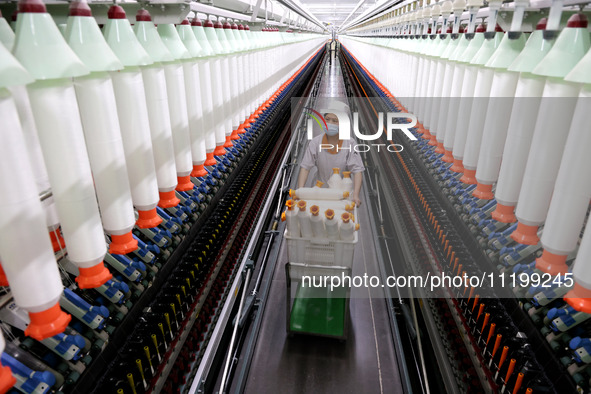 A worker is producing high-end yarn at a workshop in the Zaozhuang Economic Development Zone in Zaozhuang, China, on May 1, 2024. 