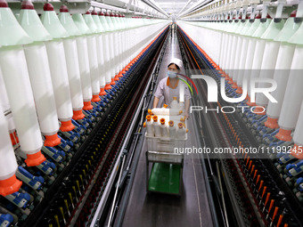 A worker is producing high-end yarn at a workshop in the Zaozhuang Economic Development Zone in Zaozhuang, China, on May 1, 2024. (