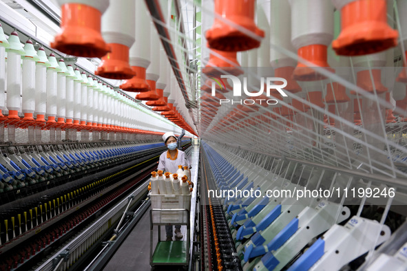 A worker is producing high-end yarn at a workshop in the Zaozhuang Economic Development Zone in Zaozhuang, China, on May 1, 2024. 