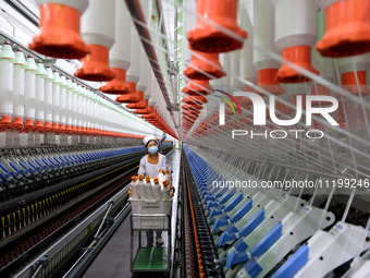 A worker is producing high-end yarn at a workshop in the Zaozhuang Economic Development Zone in Zaozhuang, China, on May 1, 2024. (