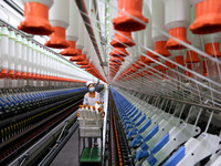 A worker is producing high-end yarn at a workshop in the Zaozhuang Economic Development Zone in Zaozhuang, China, on May 1, 2024. (