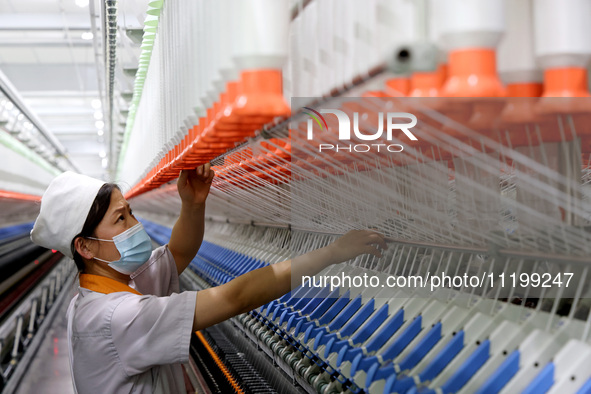 A worker is producing high-end yarn at a workshop in the Zaozhuang Economic Development Zone in Zaozhuang, China, on May 1, 2024. 