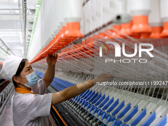 A worker is producing high-end yarn at a workshop in the Zaozhuang Economic Development Zone in Zaozhuang, China, on May 1, 2024. (