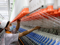 A worker is producing high-end yarn at a workshop in the Zaozhuang Economic Development Zone in Zaozhuang, China, on May 1, 2024. (