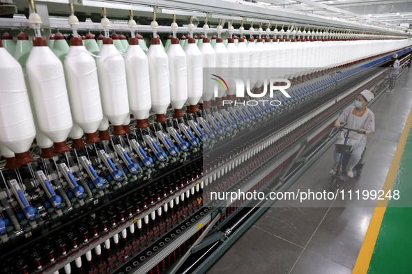 A worker is producing high-end yarn at a workshop in the Zaozhuang Economic Development Zone in Zaozhuang, China, on May 1, 2024. 