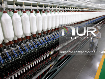 A worker is producing high-end yarn at a workshop in the Zaozhuang Economic Development Zone in Zaozhuang, China, on May 1, 2024. (