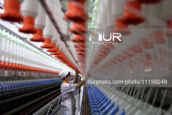 A worker is producing high-end yarn at a workshop in the Zaozhuang Economic Development Zone in Zaozhuang, China, on May 1, 2024. 