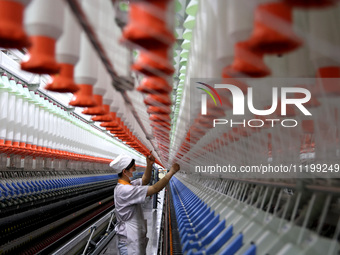 A worker is producing high-end yarn at a workshop in the Zaozhuang Economic Development Zone in Zaozhuang, China, on May 1, 2024. (