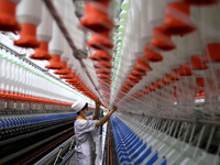 A worker is producing high-end yarn at a workshop in the Zaozhuang Economic Development Zone in Zaozhuang, China, on May 1, 2024. (