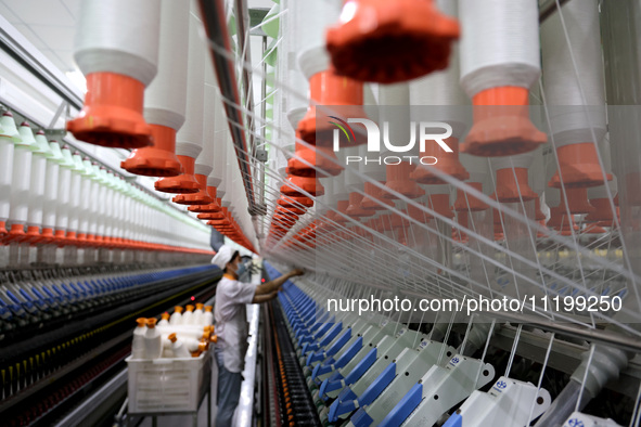 A worker is producing high-end yarn at a workshop in the Zaozhuang Economic Development Zone in Zaozhuang, China, on May 1, 2024. 