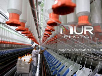 A worker is producing high-end yarn at a workshop in the Zaozhuang Economic Development Zone in Zaozhuang, China, on May 1, 2024. (