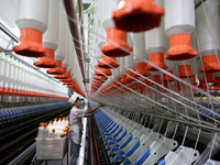 A worker is producing high-end yarn at a workshop in the Zaozhuang Economic Development Zone in Zaozhuang, China, on May 1, 2024. (