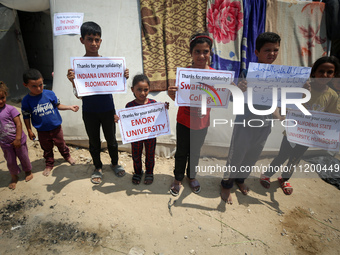 Palestinian youths are lifting placards to thank pro-Palestinian student solidarity initiatives in US and Canadian universities on their cam...