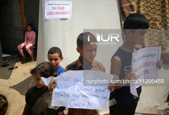 Palestinian youths are lifting placards to thank pro-Palestinian student solidarity initiatives in US and Canadian universities on their cam...