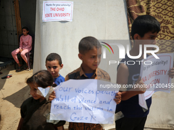 Palestinian youths are lifting placards to thank pro-Palestinian student solidarity initiatives in US and Canadian universities on their cam...