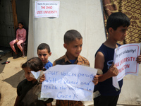 Palestinian youths are lifting placards to thank pro-Palestinian student solidarity initiatives in US and Canadian universities on their cam...