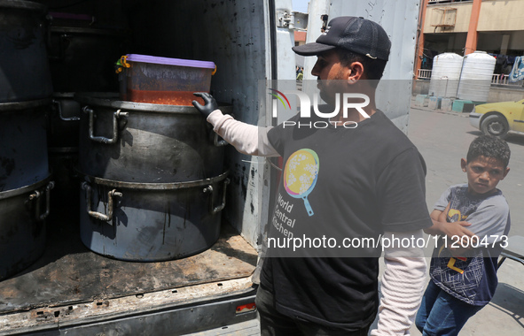 A World Central Kitchen (WCK) worker is preparing to serve meals to Palestinians at a school sheltering displaced people amid the ongoing co...