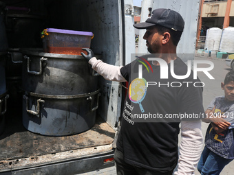 A World Central Kitchen (WCK) worker is preparing to serve meals to Palestinians at a school sheltering displaced people amid the ongoing co...