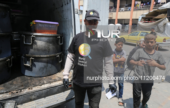 A World Central Kitchen (WCK) worker is preparing to serve meals to Palestinians at a school sheltering displaced people amid the ongoing co...