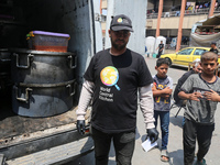 A World Central Kitchen (WCK) worker is preparing to serve meals to Palestinians at a school sheltering displaced people amid the ongoing co...