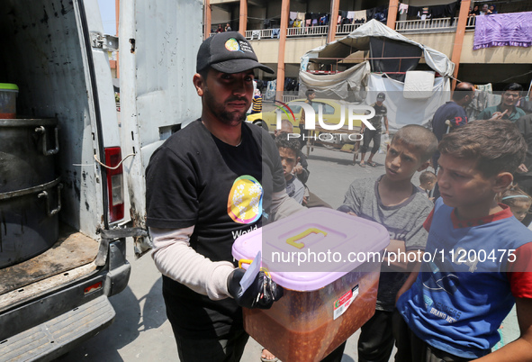 A World Central Kitchen (WCK) worker is preparing to serve meals to Palestinians at a school sheltering displaced people amid the ongoing co...