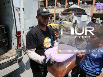 A World Central Kitchen (WCK) worker is preparing to serve meals to Palestinians at a school sheltering displaced people amid the ongoing co...