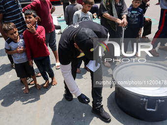 A World Central Kitchen (WCK) worker is preparing to serve meals to Palestinians at a school sheltering displaced people amid the ongoing co...