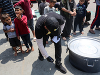 A World Central Kitchen (WCK) worker is preparing to serve meals to Palestinians at a school sheltering displaced people amid the ongoing co...