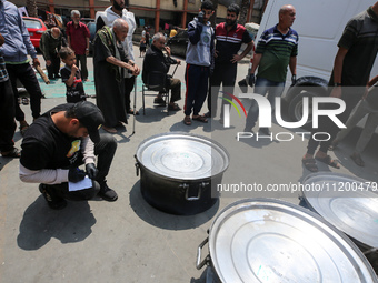 A World Central Kitchen (WCK) worker is preparing to serve meals to Palestinians at a school sheltering displaced people amid the ongoing co...