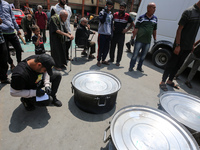 A World Central Kitchen (WCK) worker is preparing to serve meals to Palestinians at a school sheltering displaced people amid the ongoing co...