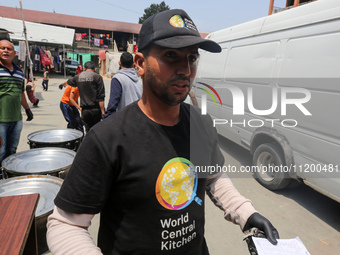 A World Central Kitchen (WCK) worker is preparing to serve meals to Palestinians at a school sheltering displaced people amid the ongoing co...