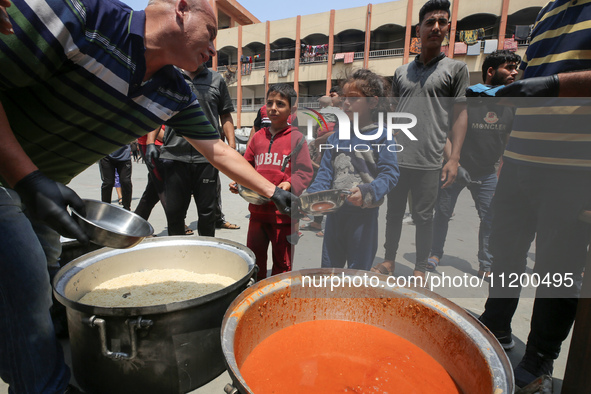 Palestinians are gathering to receive food meals cooked by World Central Kitchen (WCK) after the charity resumed operations at a school shel...