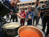 Palestinians are gathering to receive food meals cooked by World Central Kitchen (WCK) after the charity resumed operations at a school shel...