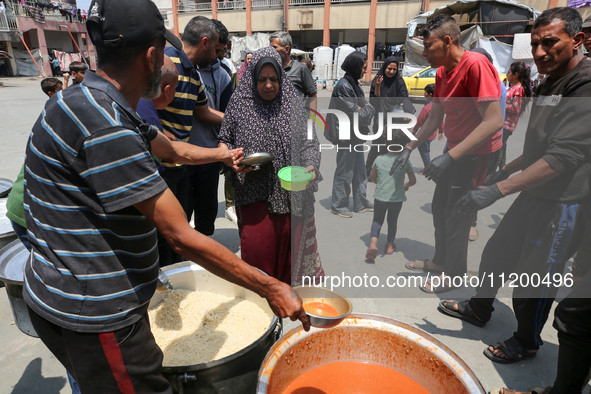 Palestinians are gathering to receive food meals cooked by World Central Kitchen (WCK) after the charity resumed operations at a school shel...