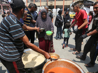 Palestinians are gathering to receive food meals cooked by World Central Kitchen (WCK) after the charity resumed operations at a school shel...