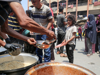 Palestinians are gathering to receive food meals cooked by World Central Kitchen (WCK) after the charity resumed operations at a school shel...