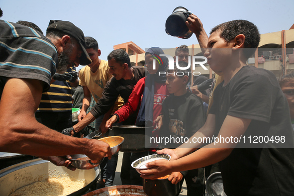 Palestinians are gathering to receive food meals cooked by World Central Kitchen (WCK) after the charity resumed operations at a school shel...