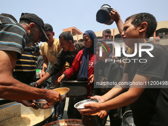 Palestinians are gathering to receive food meals cooked by World Central Kitchen (WCK) after the charity resumed operations at a school shel...