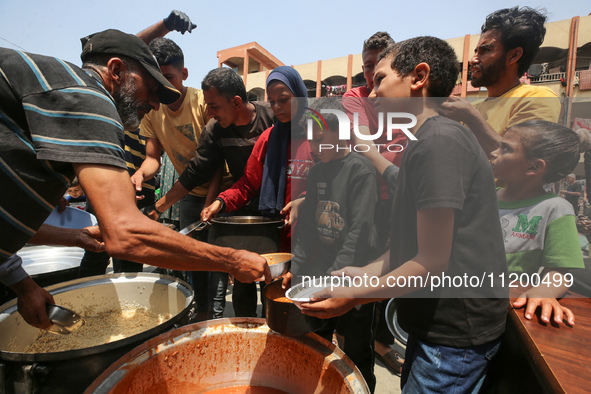 Palestinians are gathering to receive food meals cooked by World Central Kitchen (WCK) after the charity resumed operations at a school shel...