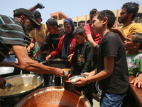 Palestinians are gathering to receive food meals cooked by World Central Kitchen (WCK) after the charity resumed operations at a school shel...