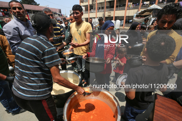 Palestinians are gathering to receive food meals cooked by World Central Kitchen (WCK) after the charity resumed operations at a school shel...