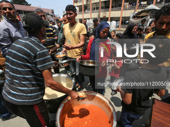 Palestinians are gathering to receive food meals cooked by World Central Kitchen (WCK) after the charity resumed operations at a school shel...