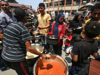 Palestinians are gathering to receive food meals cooked by World Central Kitchen (WCK) after the charity resumed operations at a school shel...