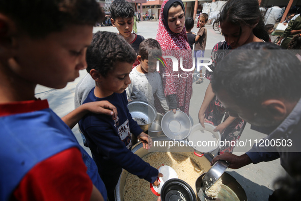 Palestinians are gathering to receive food meals cooked by World Central Kitchen (WCK) after the charity resumed operations at a school shel...