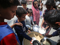 Palestinians are gathering to receive food meals cooked by World Central Kitchen (WCK) after the charity resumed operations at a school shel...