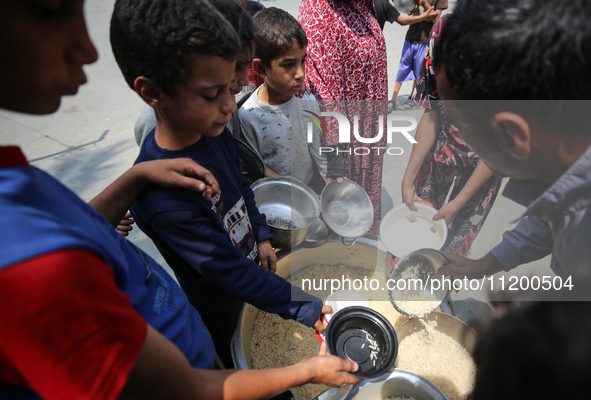 Palestinians are gathering to receive food meals cooked by World Central Kitchen (WCK) after the charity resumed operations at a school shel...