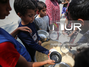 Palestinians are gathering to receive food meals cooked by World Central Kitchen (WCK) after the charity resumed operations at a school shel...